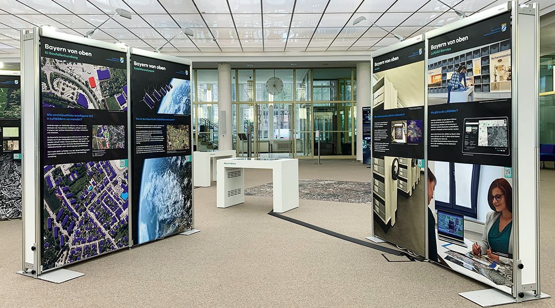 Wanderausstellung heller Ausstellungsraum mit Stelltafeln und kleinen Tischen